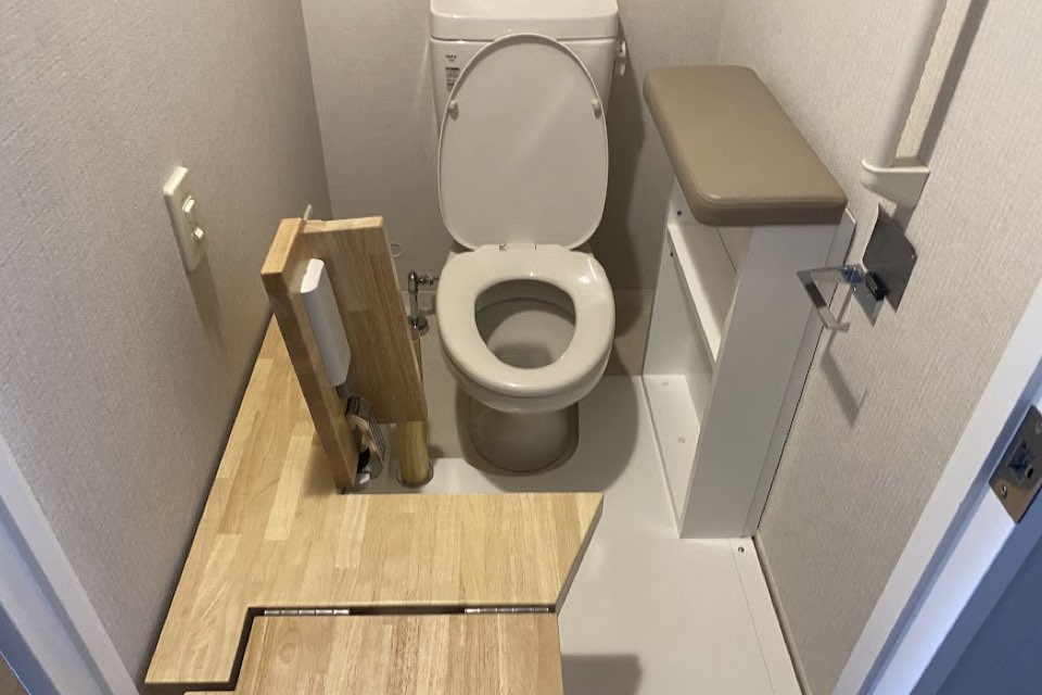 車いすから便器まで「横すべりで移乗できる」跳ね上げ式トイレ台
