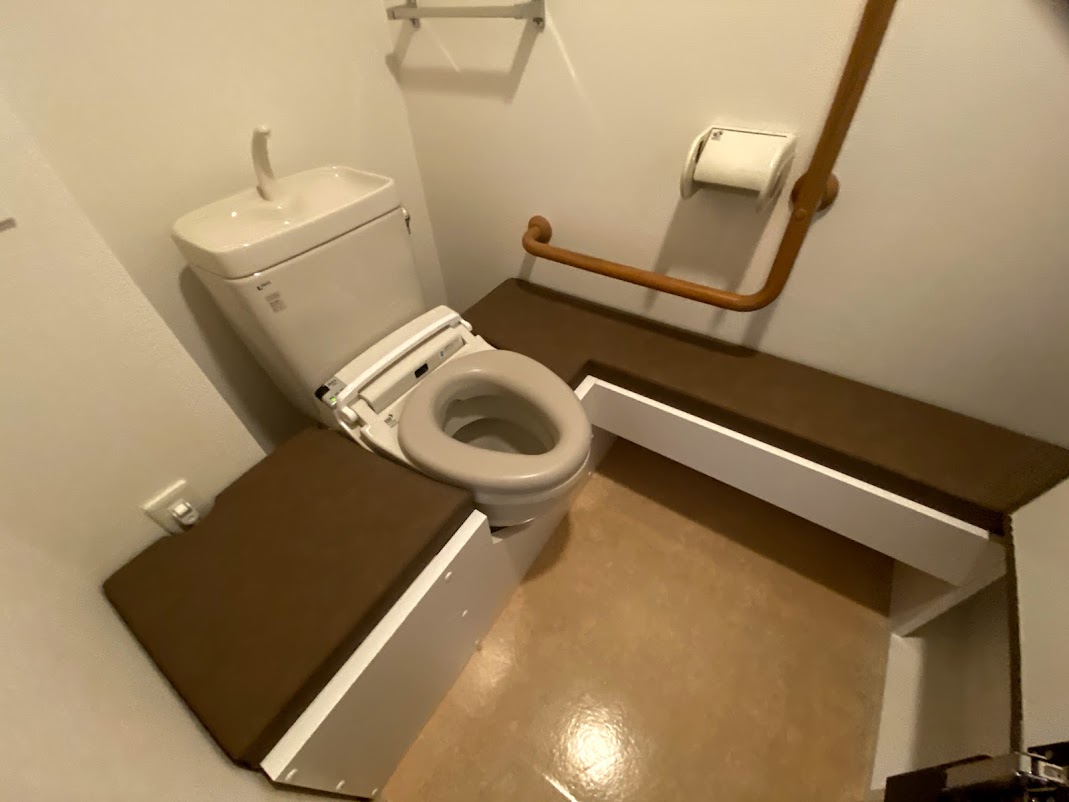 横向きトイレを、アクセシブルな跳ね上げ式トイレ台で高床に