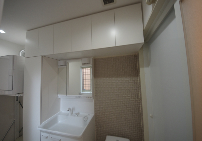 細長い洗面室を有効に使うための、洗面台と収納棚